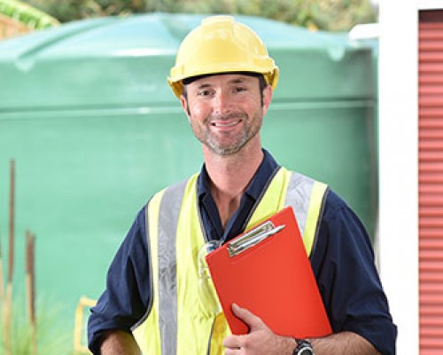 Man holding clipboard with hard hat