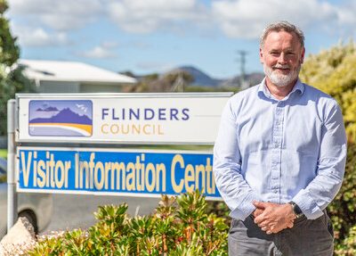 Warren Groves in front of Flinders Council sign